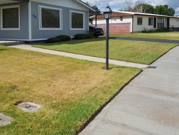 A large residential home that has recently been mowed by Telos Lawn Care. The grass has been neatly cut and the sidewalk and walkway has been edged.