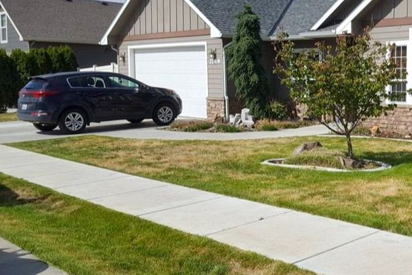 The same residential home as before, but now after a yard cleanup service by Telos Lawn Care. The overgrown grass has been neatly mowed and all leaves, clippings, and debris have been cleaned up.